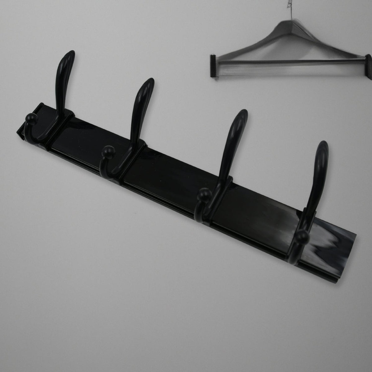 Top-down view of the 4-hook wall mount coat hanger holding various coats and hats.